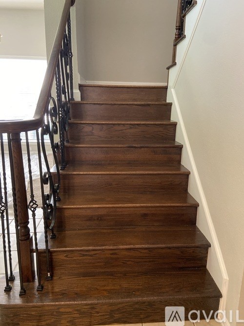 A wooden staircase with a metal railing.