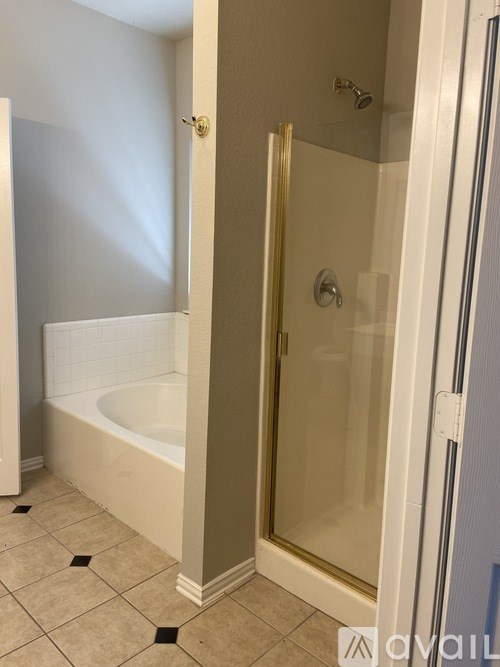 A bathroom with a white tub and a glass shower door.