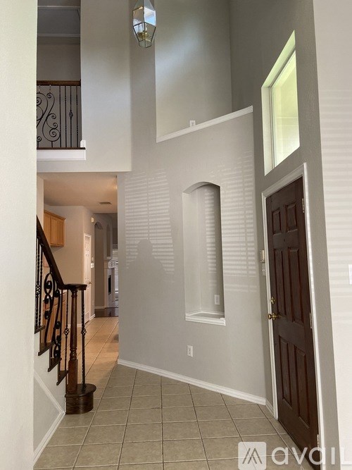 A hallway with a staircase and a door.