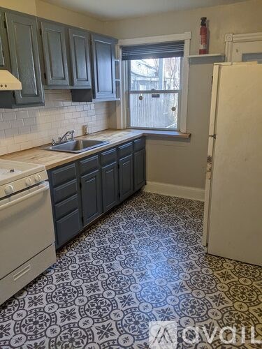 A kitchen with a white stove top oven and a white sink.