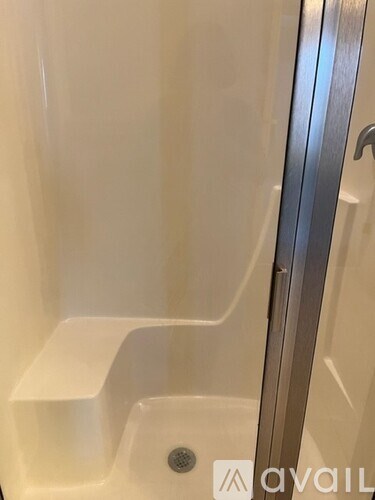 A white sink in a bathroom with a silver faucet.
