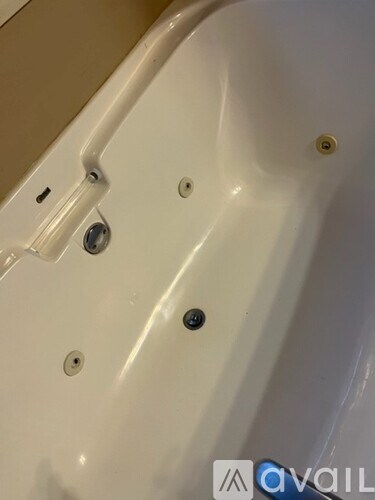 A white bathtub with four visible screws.