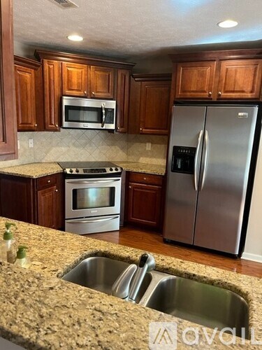 A kitchen with brown cabinets and a granite countertop.