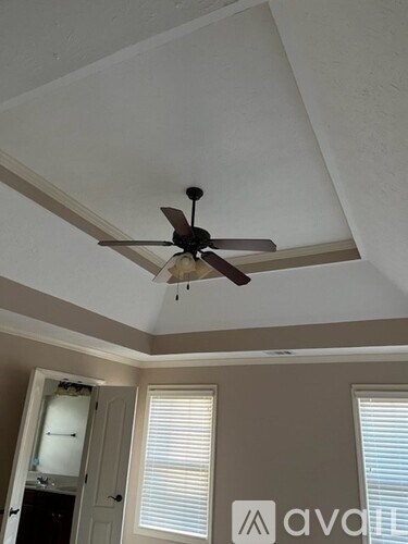 A ceiling fan is hanging from a ceiling in a room.