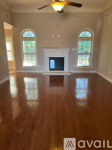 A living room with a fireplace and wood flooring.