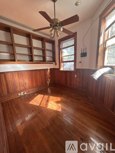 A room with wooden floors and a ceiling fan.