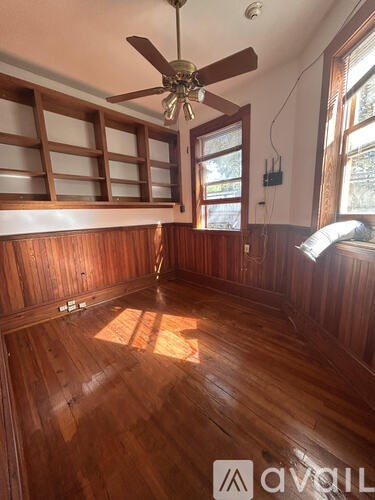 A room with wooden floors and a ceiling fan.