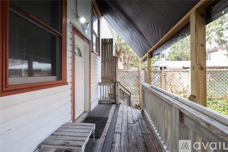 A wooden deck with a bench and a railing.