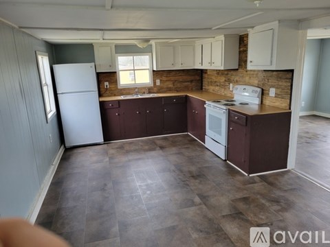 A kitchen with a white refrigerator and brown cabinets.