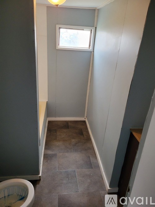 A bathroom with a toilet and a window.