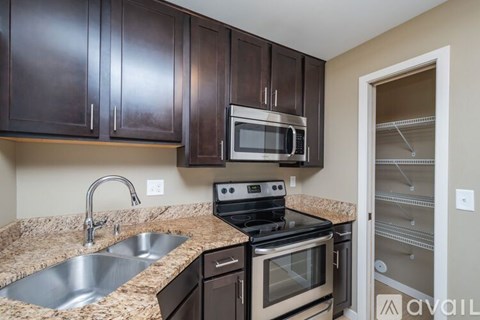 A kitchen with brown cabinets and a granite countertop.
