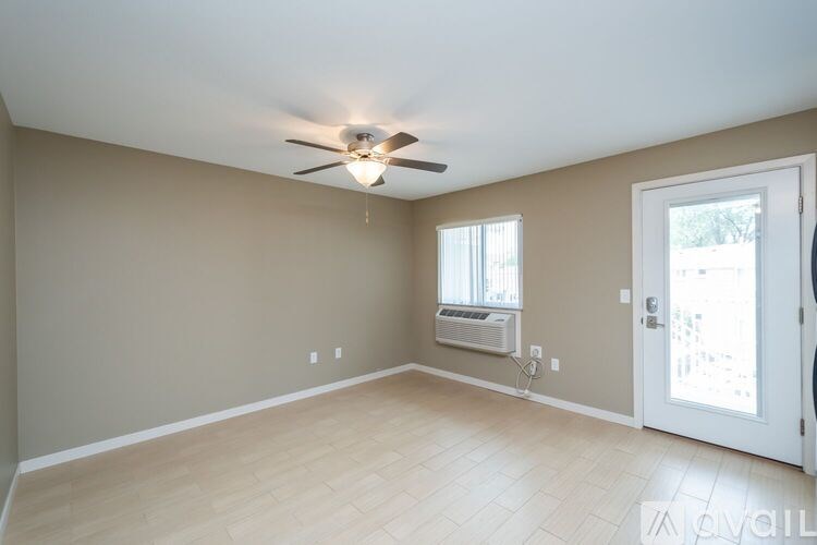 A room with a ceiling fan and a window with blinds.