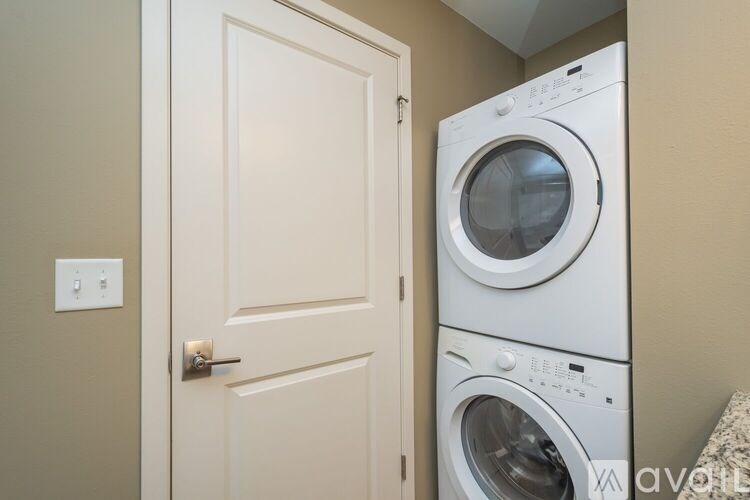 A white door is open to a laundry room with a washer and dryer.