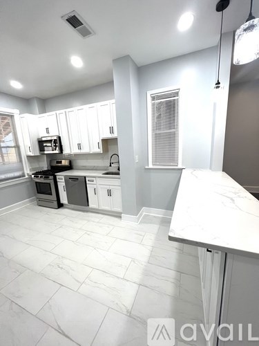 A kitchen with white cabinets and a marble countertop.