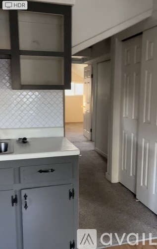 A kitchen with a white counter top and cabinets.