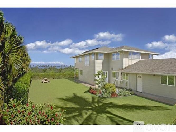 A house with a lawn and a car parked in front.