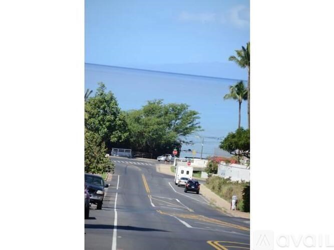 A street with cars and trees on the side.