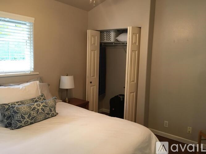 A bedroom with a bed, lamp, and closet.