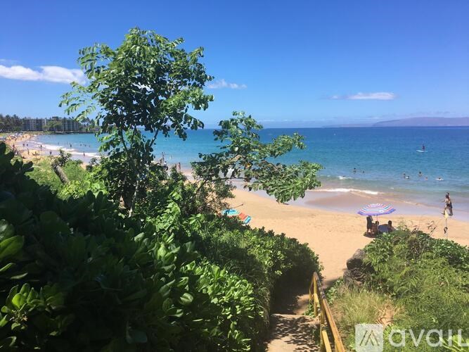 A beach scene with people and umbrellas on the sand.