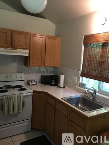 A kitchen with wooden cabinets and a white stove top oven.