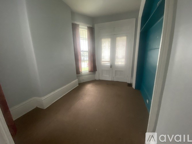 A room with brown flooring and white walls.