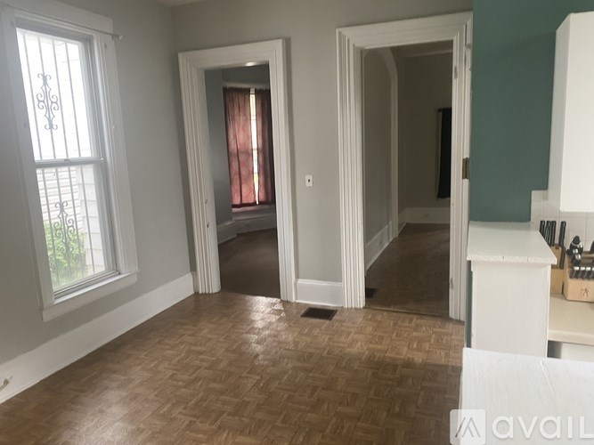 A room with a window and a door leading to another room.