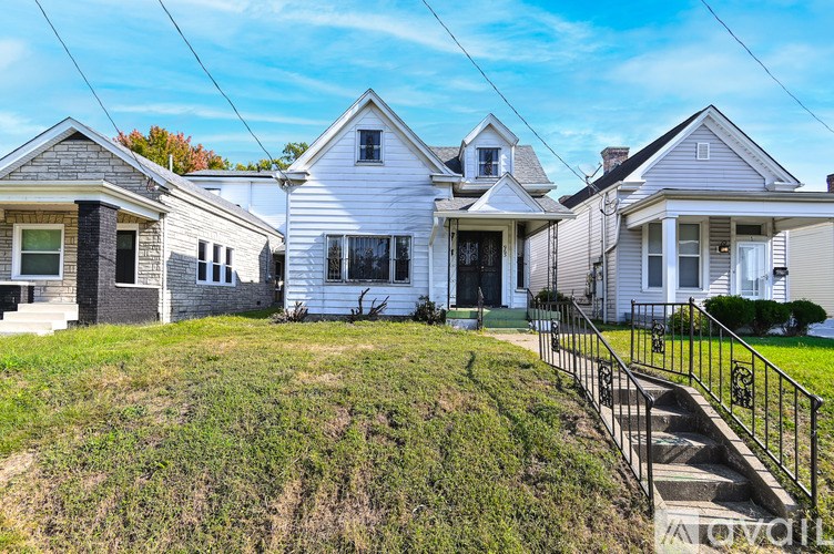 A white house with a black fence in front of it.