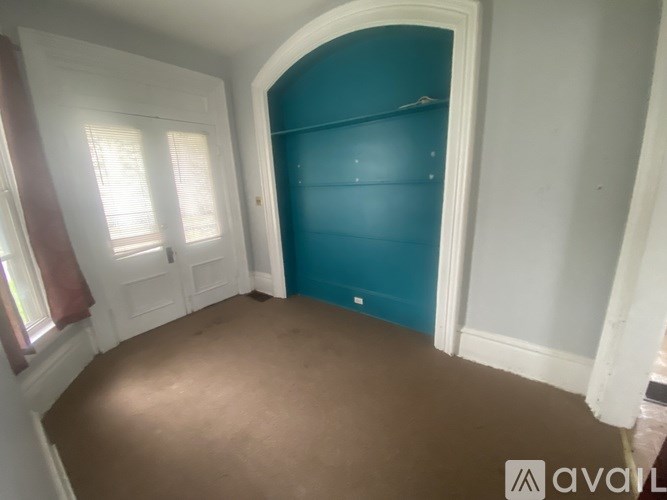 A room with a blue wardrobe and brown flooring.