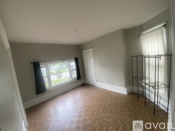 A room with a window and a door is available for rent.