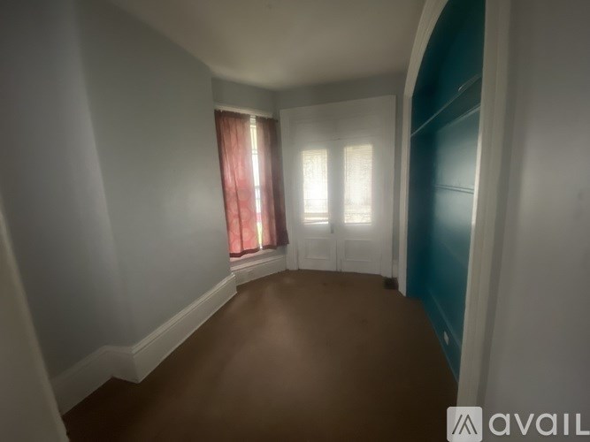 A room with a window and a curtain.