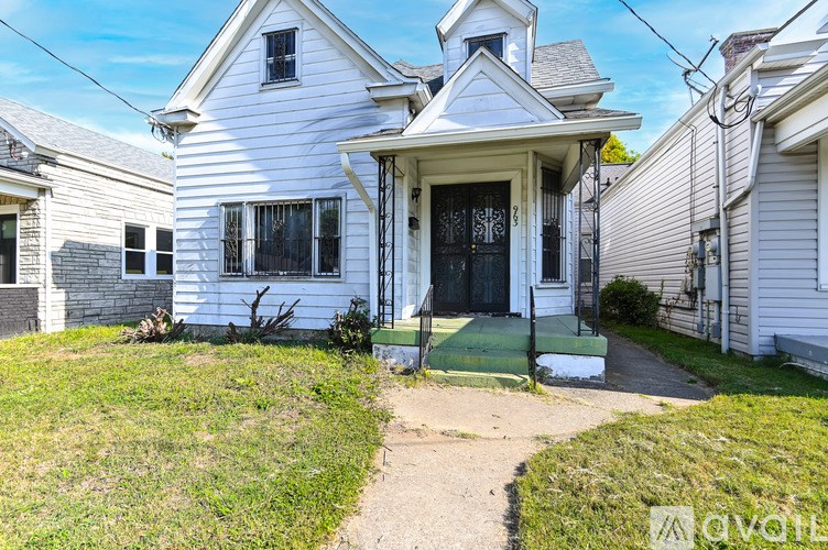 A white house with a black door and a small porch.
