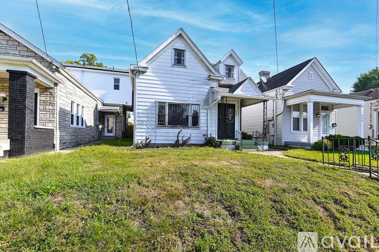 A white house with a black fence in front of it.