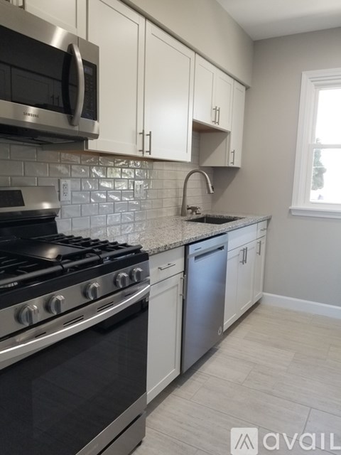A kitchen with a black stove top oven and white cabinets.