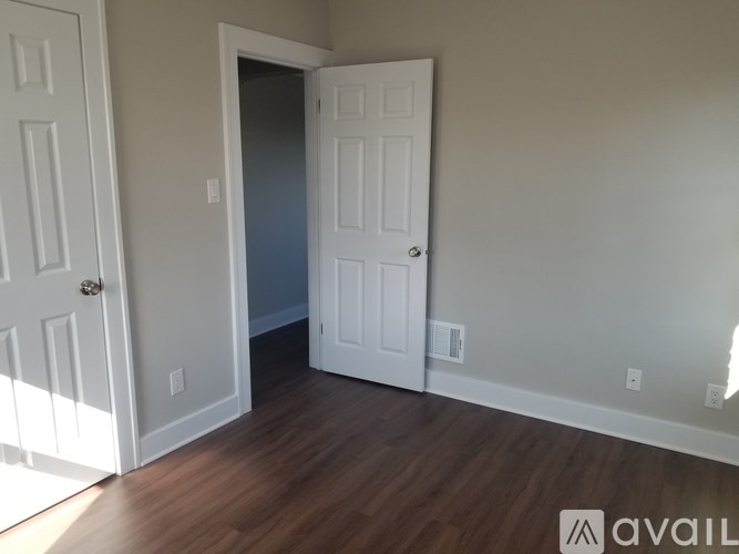 A room with a white door and a white wall.