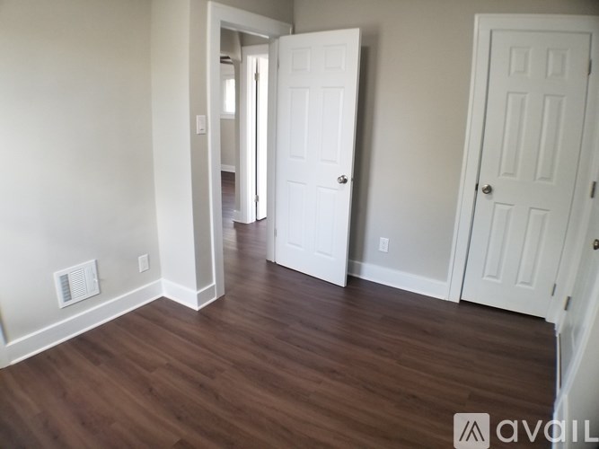 A room with white doors and wooden floors.