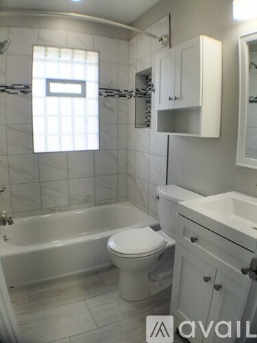 A white bathroom with a toilet, sink and tub.