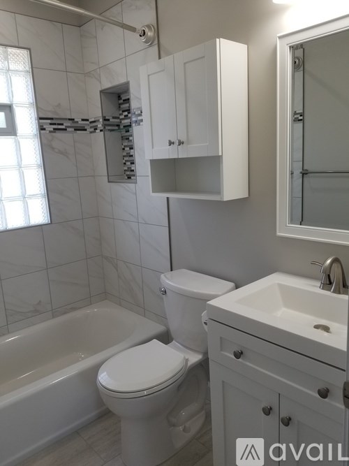 A white bathroom with a toilet, sink, and bathtub.
