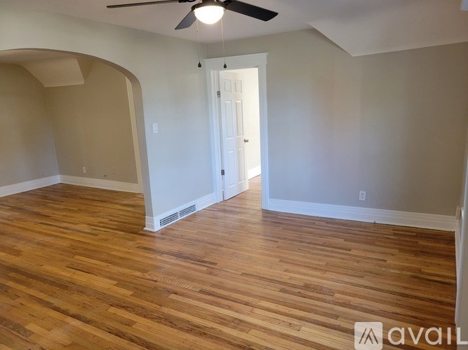 A room with wooden flooring and a ceiling fan.