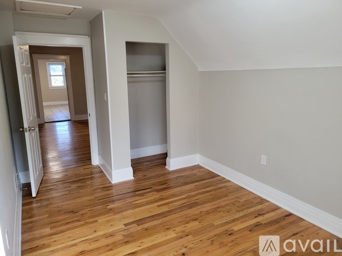 A room with wooden floors and white walls is available for rent.