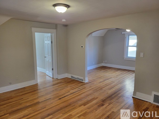A room with wooden flooring and a white door.