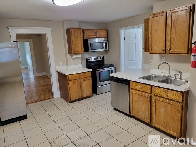 A kitchen with wooden cabinets and a white countertop.