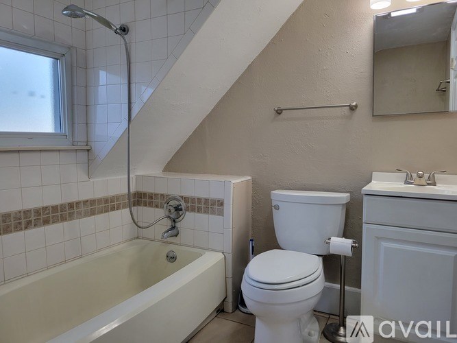 A bathroom with a white tub, toilet, and sink.