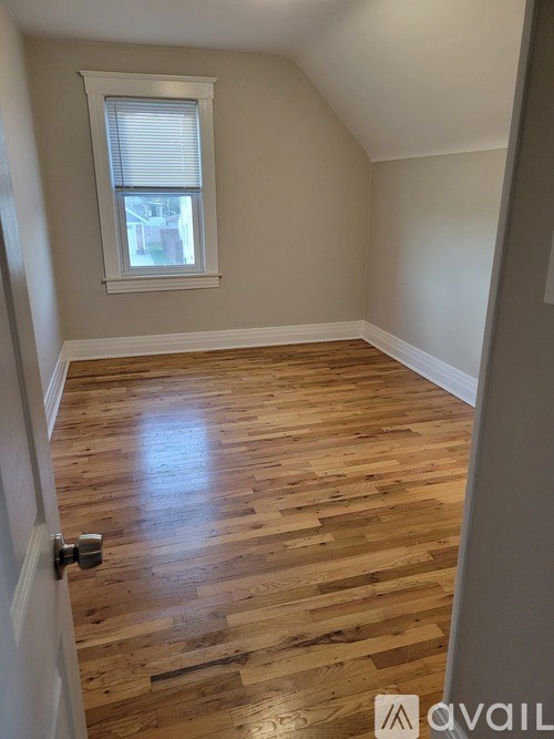 A room with wooden flooring and a window.