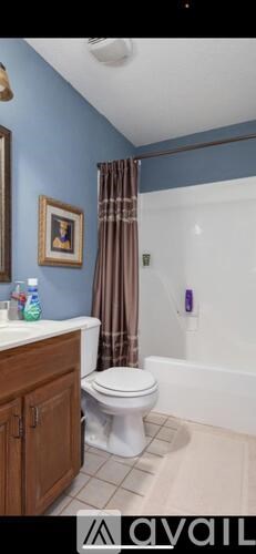 A bathroom with blue walls and a white toilet.