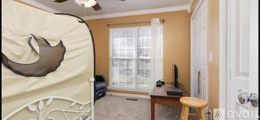 A room with a bed, desk, and window.
