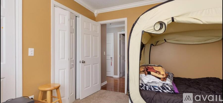 A room with a bunk bed and a tan wall.