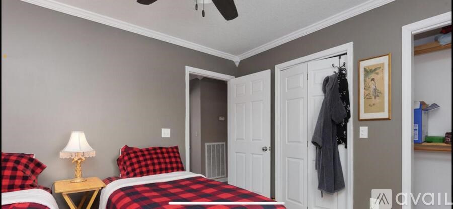 A bedroom with two beds and a ceiling fan.