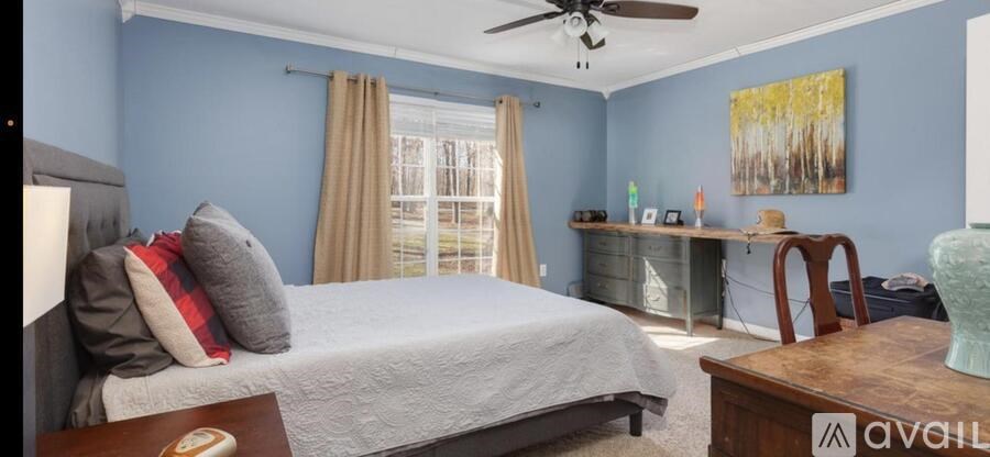 A bedroom with a bed, dresser, and a painting on the wall.