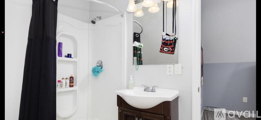 A bathroom with a white sink and a white shower.