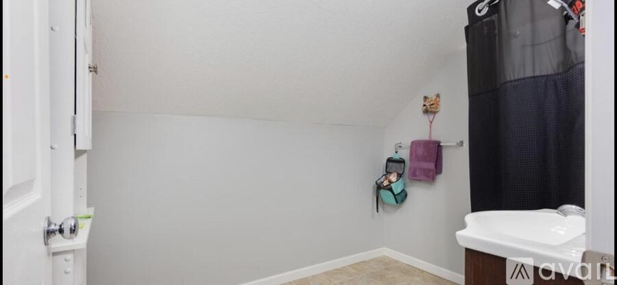 A bathroom with a white sink and a white towel hanging on the wall.
